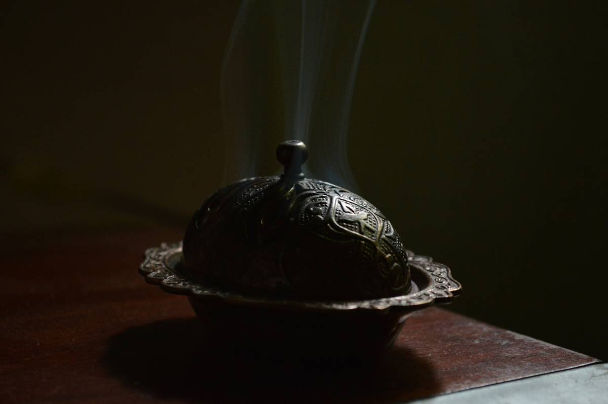 how to burn incense at home with a ceramic burner on a stone coaster surrounded by dried lavender